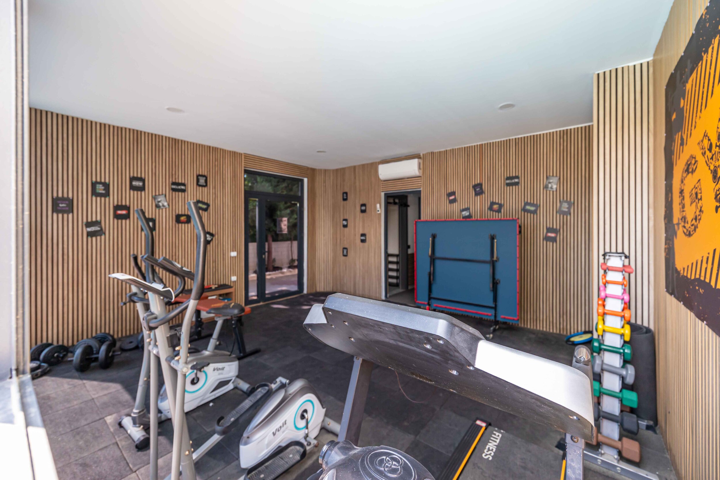Treadmill, elliptical machines and colorful dumbbells in the gym