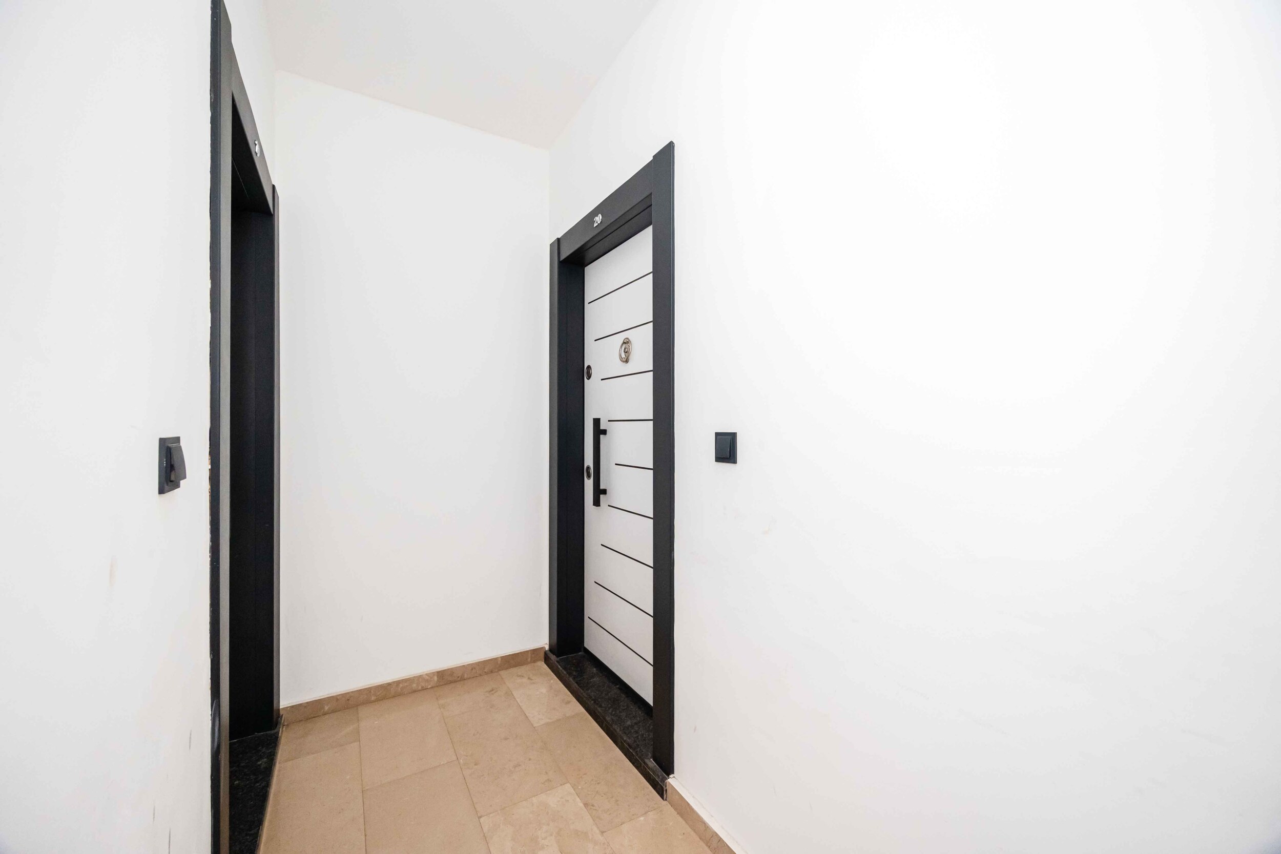 Bright hall with white walls and an entrance door in Kargicak