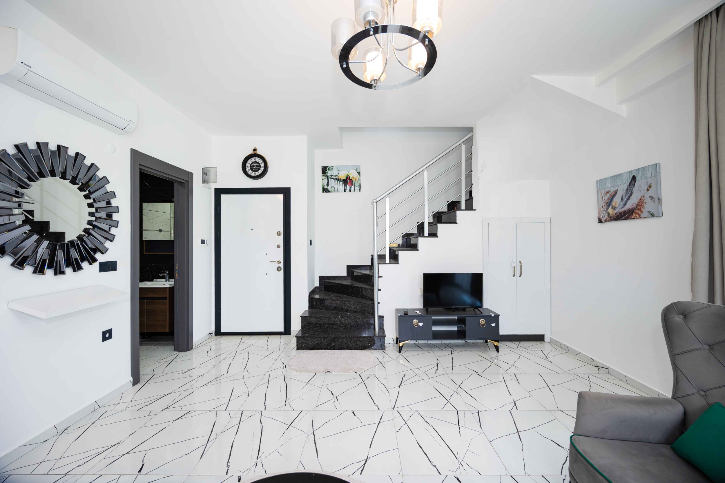 Bright living room with black staircase and marble floor in Kargicak where homes are for sale