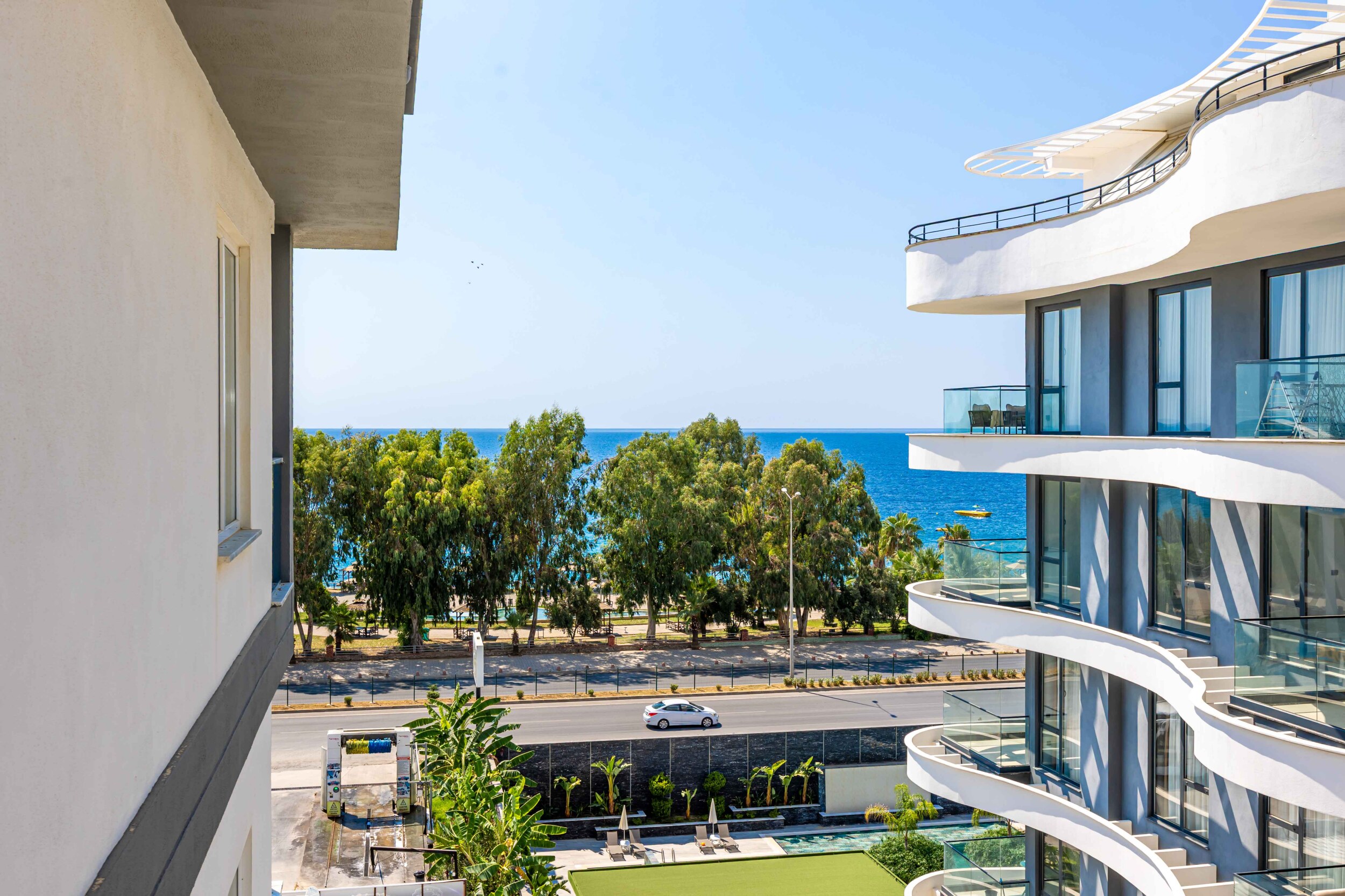Pool, green coastal area and sea at the complex in Kargicak, Turkey