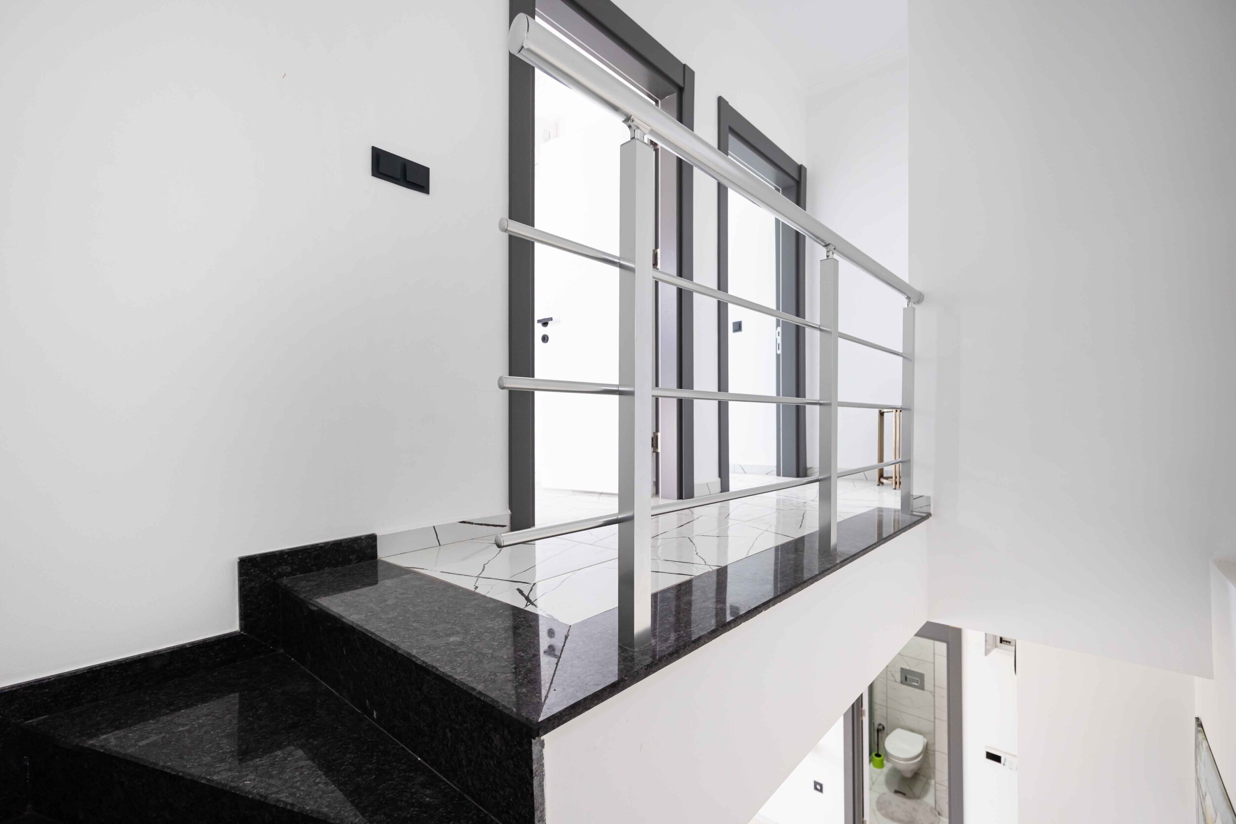 Black stone steps with glass railing in a top-floor apartment in Kargicak