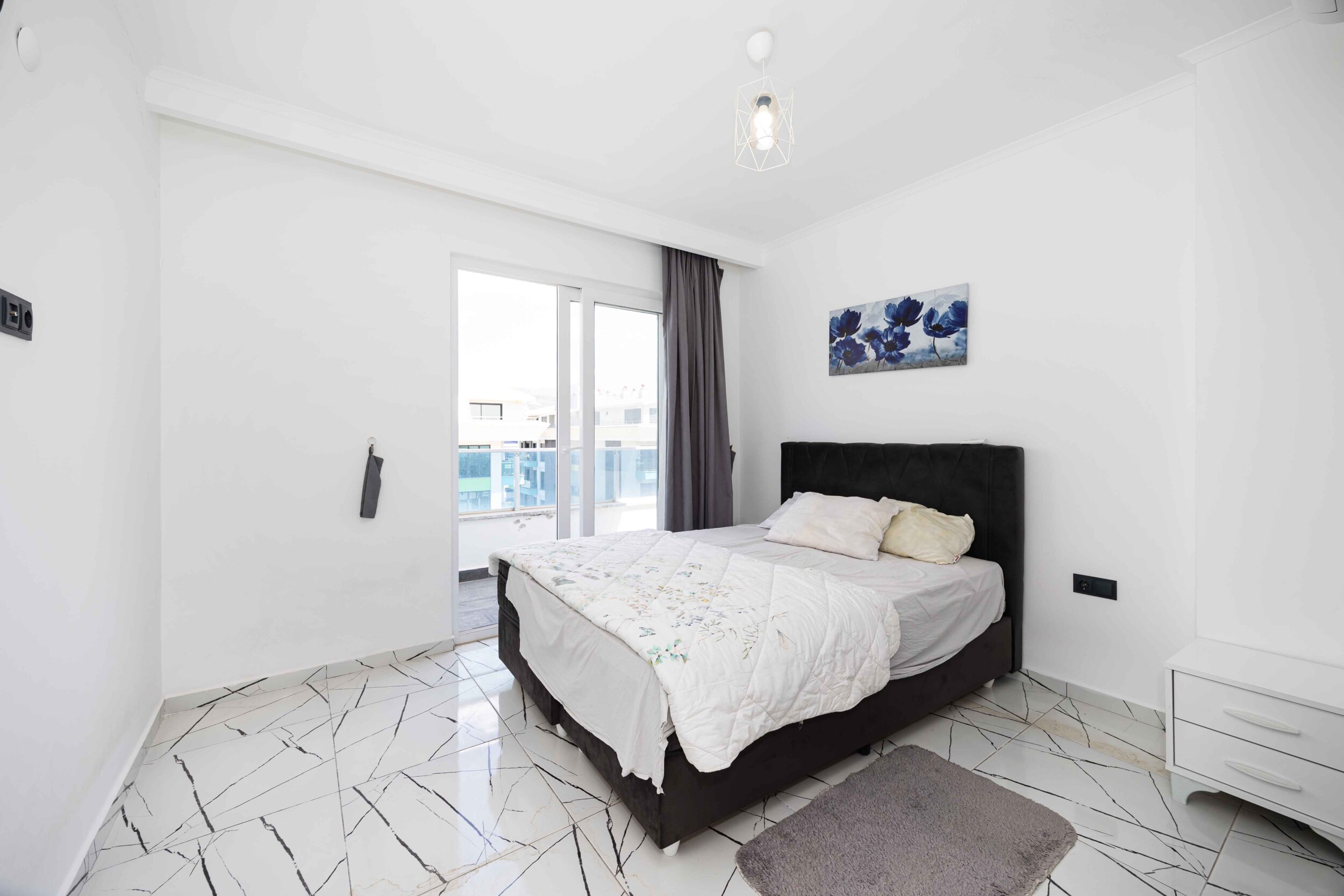 Bedroom with double bed and panoramic balcony door in a residence