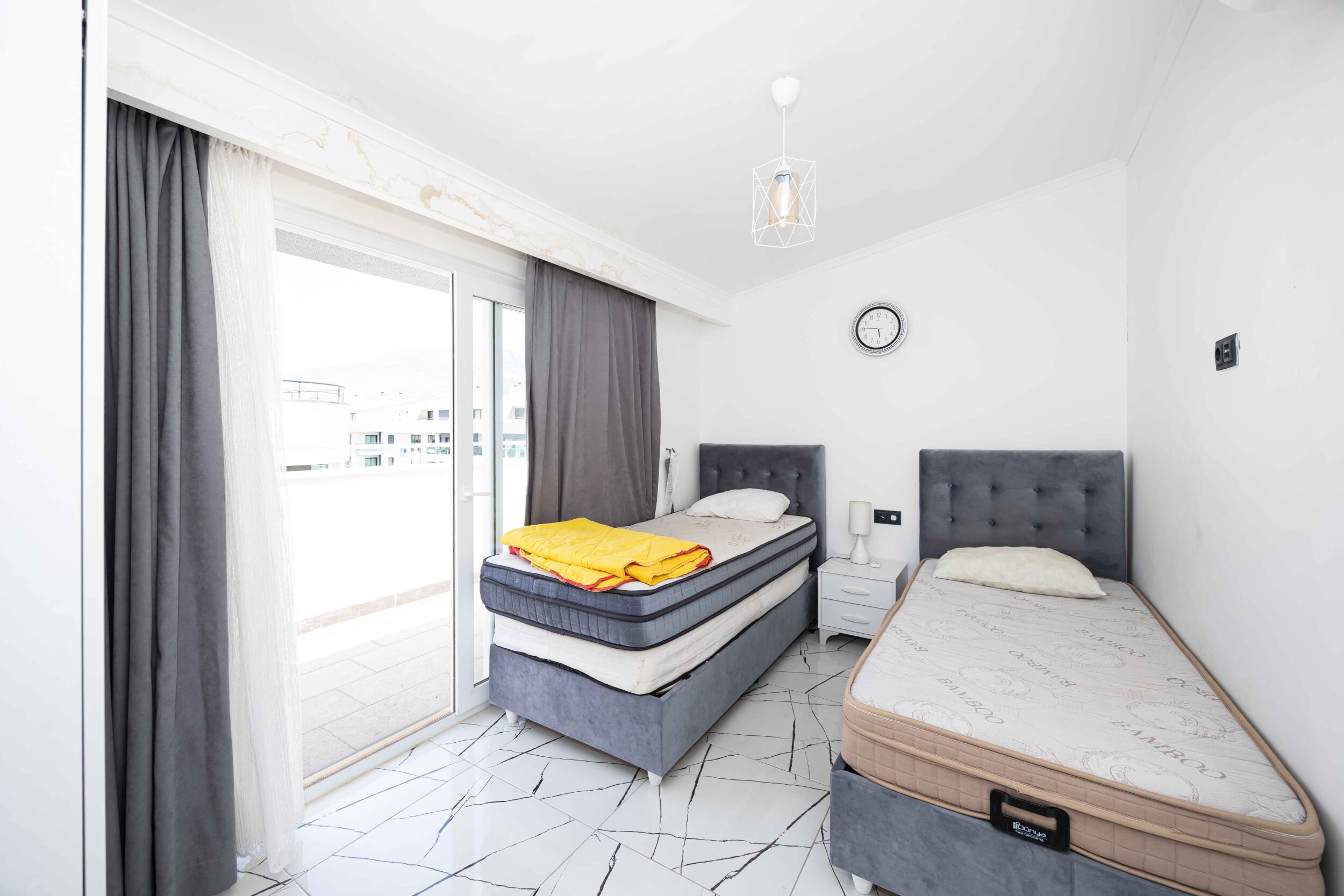 Bedroom with twin beds and a balcony door in a penthouse