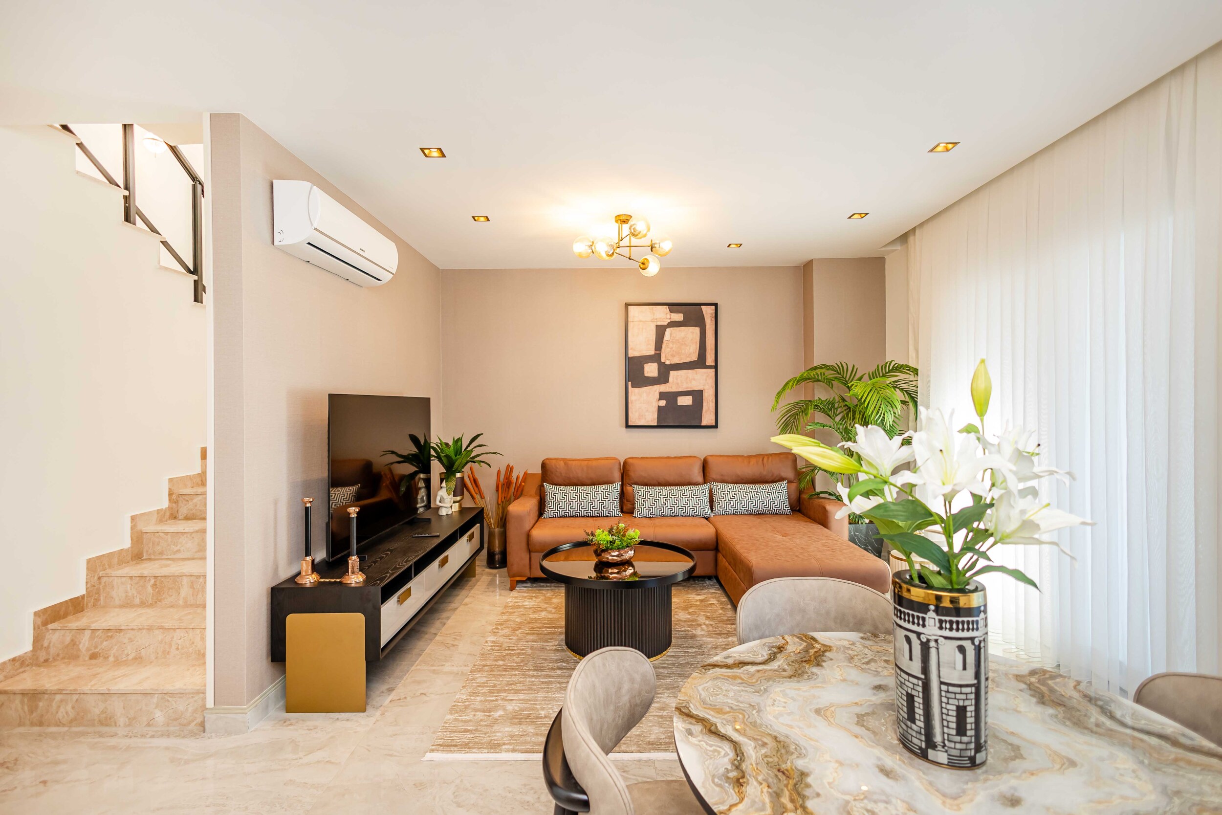 Living room with a corner sofa and panoramic window in a penthouse for sale in Turkey