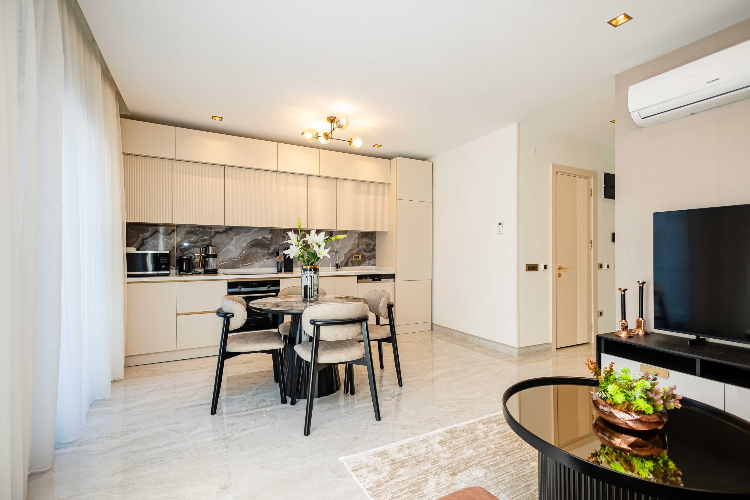 Kitchen with light cabinetry, full-height cupboards and a marble backsplash