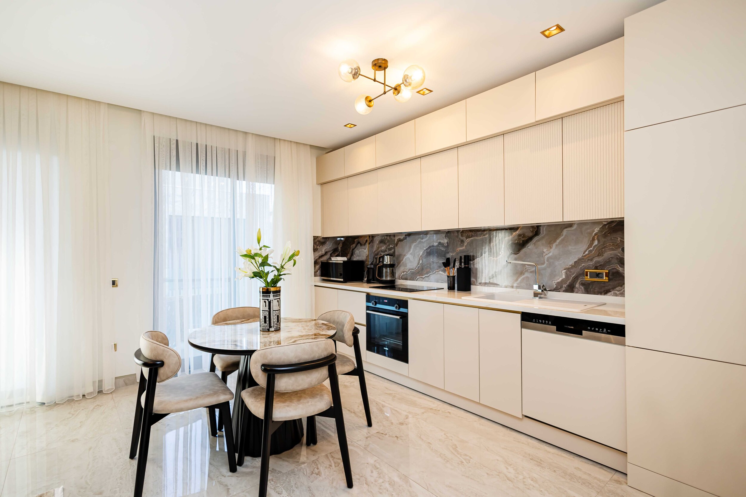 Kitchen-living room with beige cabinetry and an oval dining table in a residence