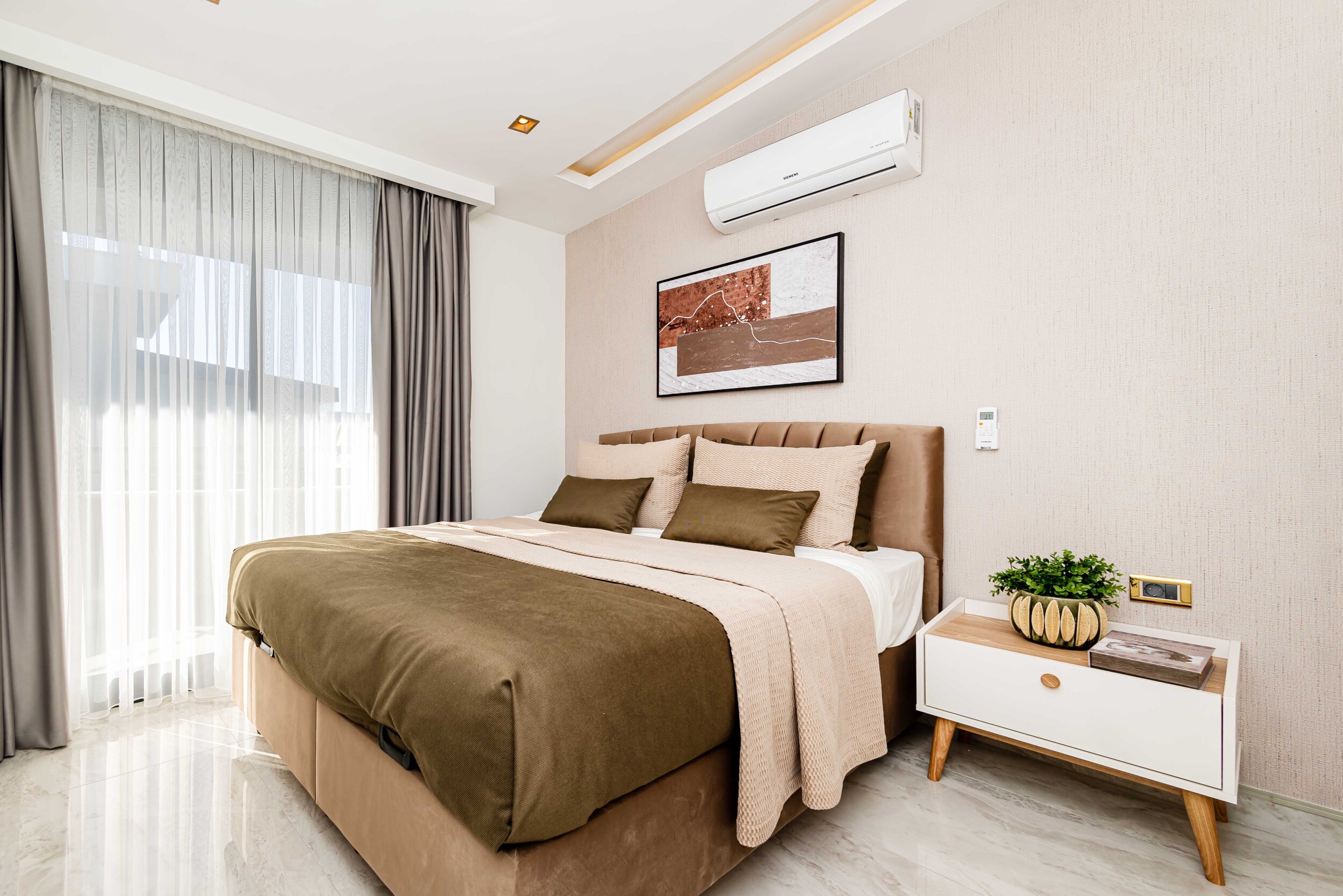 Bedroom with a double bed and panoramic window in a penthouse by the sea