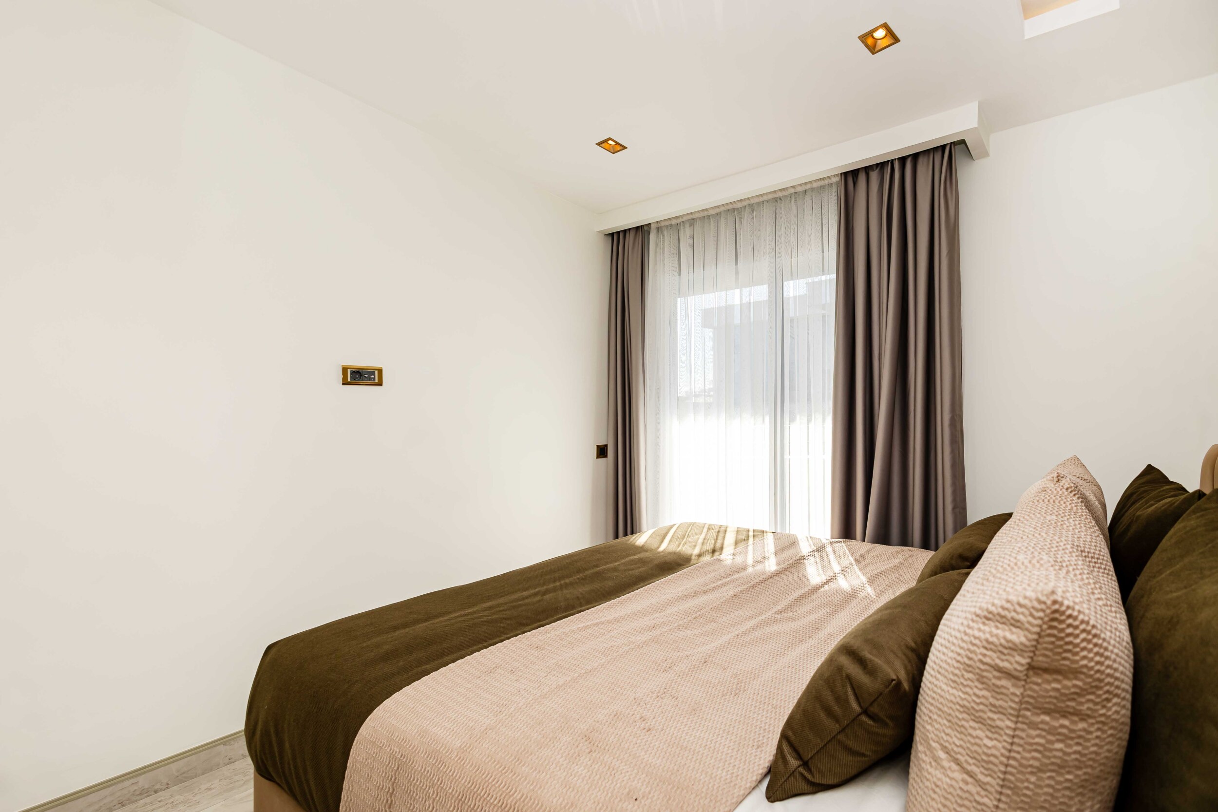Bedroom with a textured bedspread and decorative cushions in warm daylight