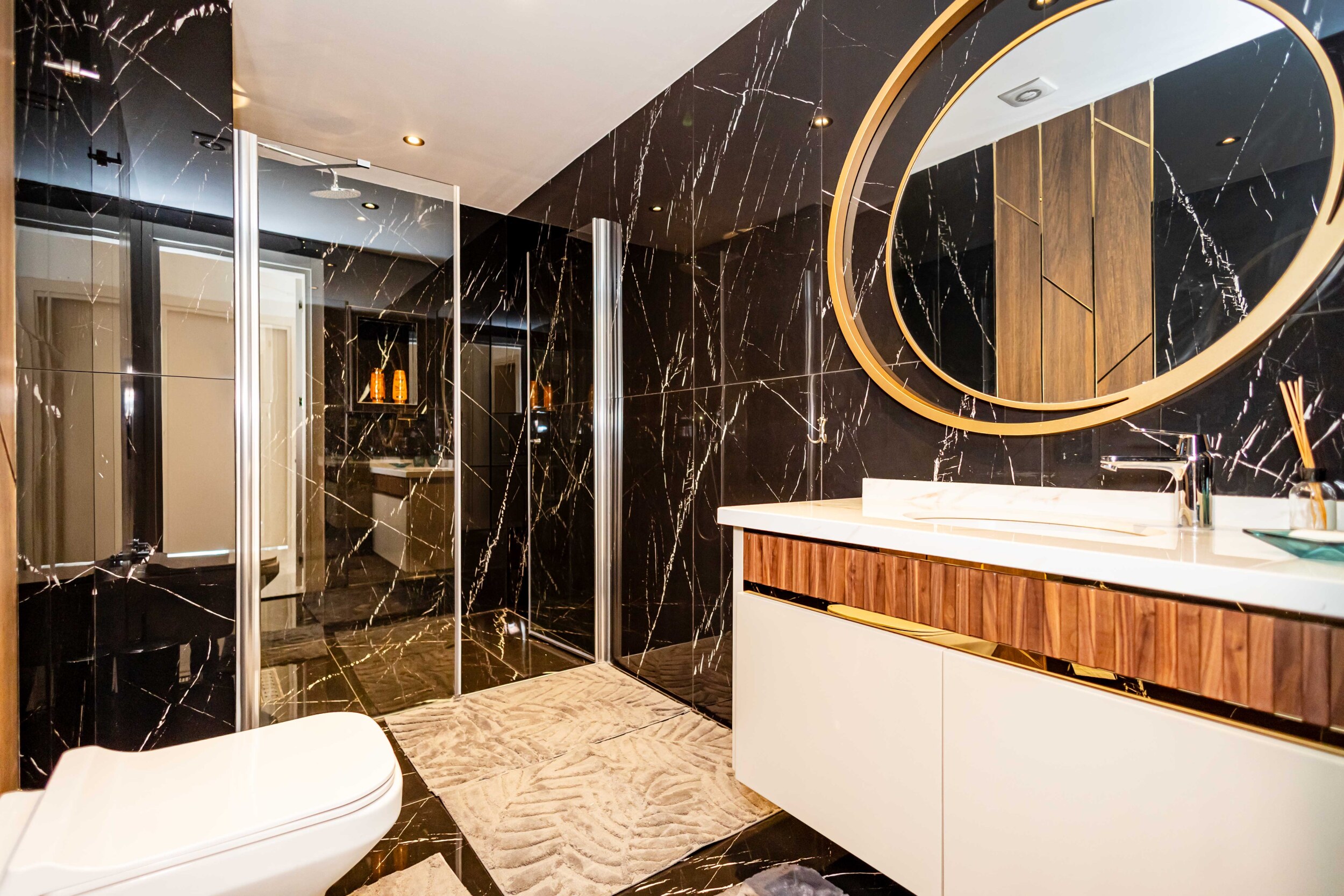Bathroom with glass shower and black marble in a penthouse by the sea
