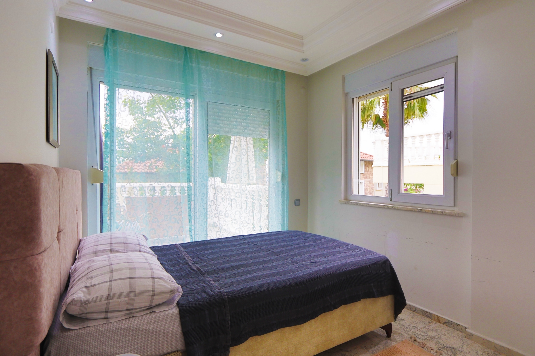 Bedroom with a single bed, balcony door and marble windowsill in a villa in Alanya