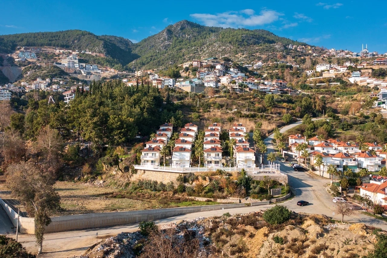 Mountain landscape with hillside homes, red roofs and winding roads, viewed from a villa for sale