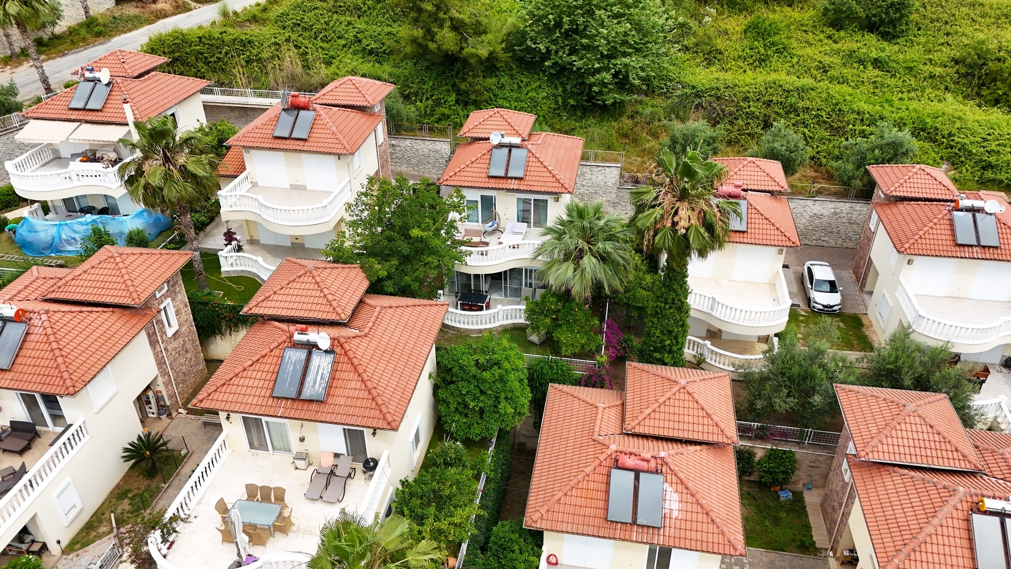Group of detached villas with red roofs, solar water heaters and round balconies