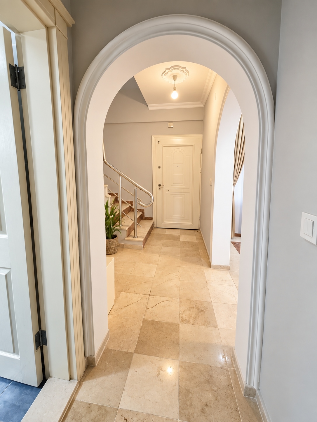 Marble-floored entry hall with an arched doorway and stairs in an Alanya villa