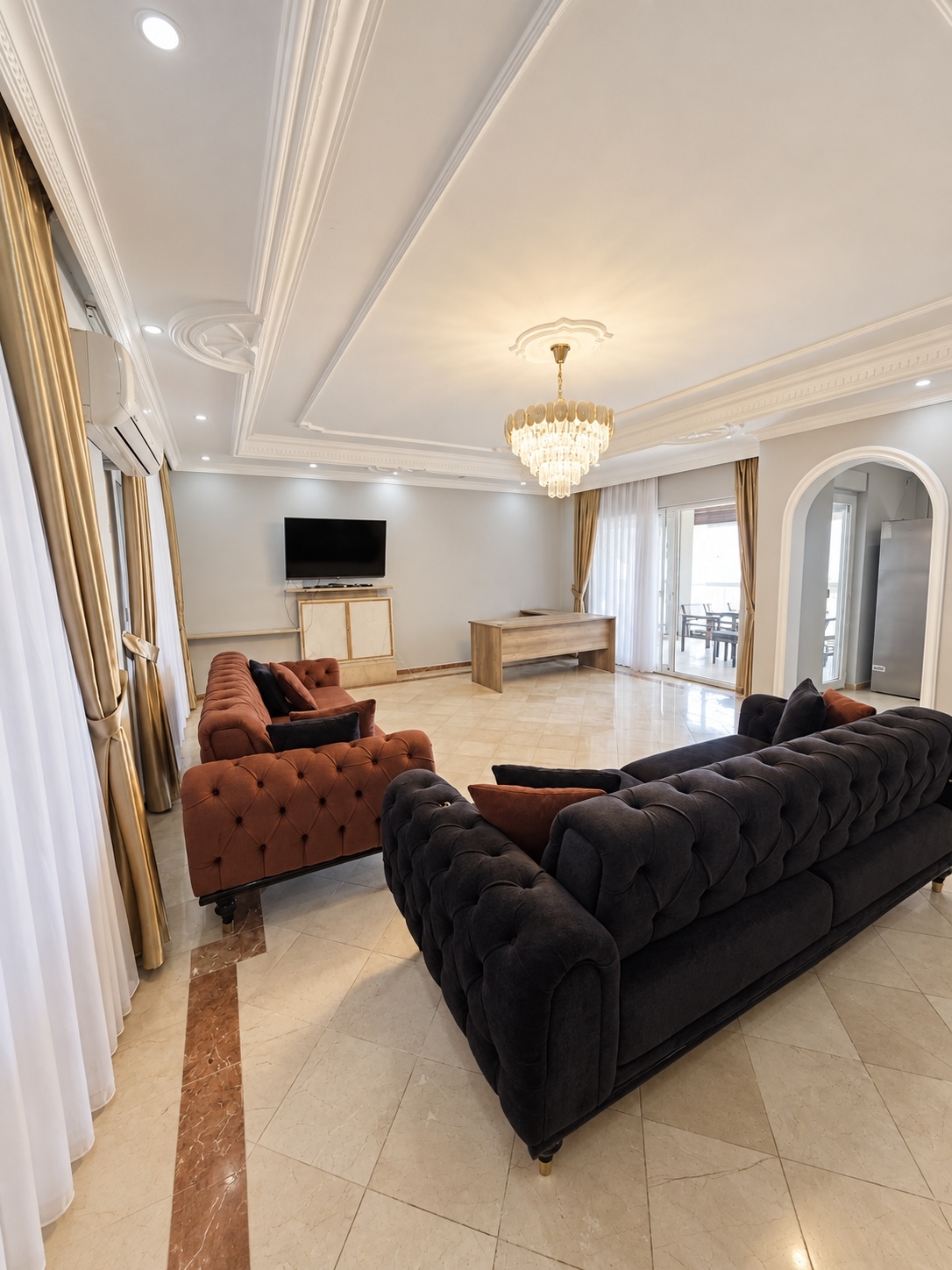 Living room with black sectional and crystal chandelier in a villa for sale in Turkey