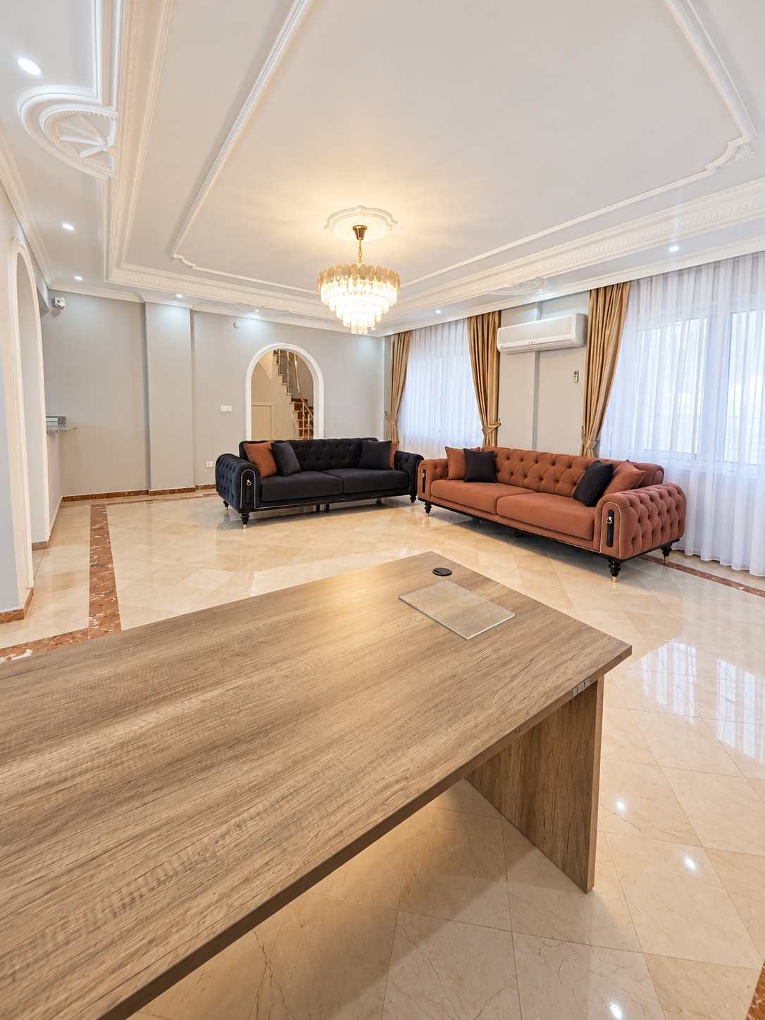 Wooden table and two sofas fill the living room of a house in Turkey