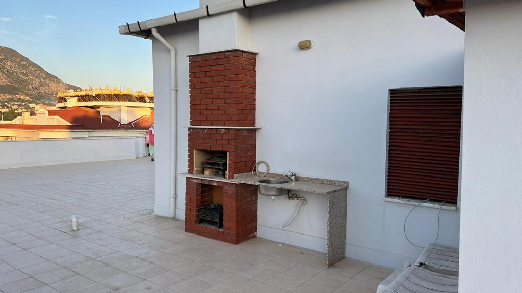 Brick outdoor fireplace and stone sink on an apartment residence terrace in Tosmur, Turkey