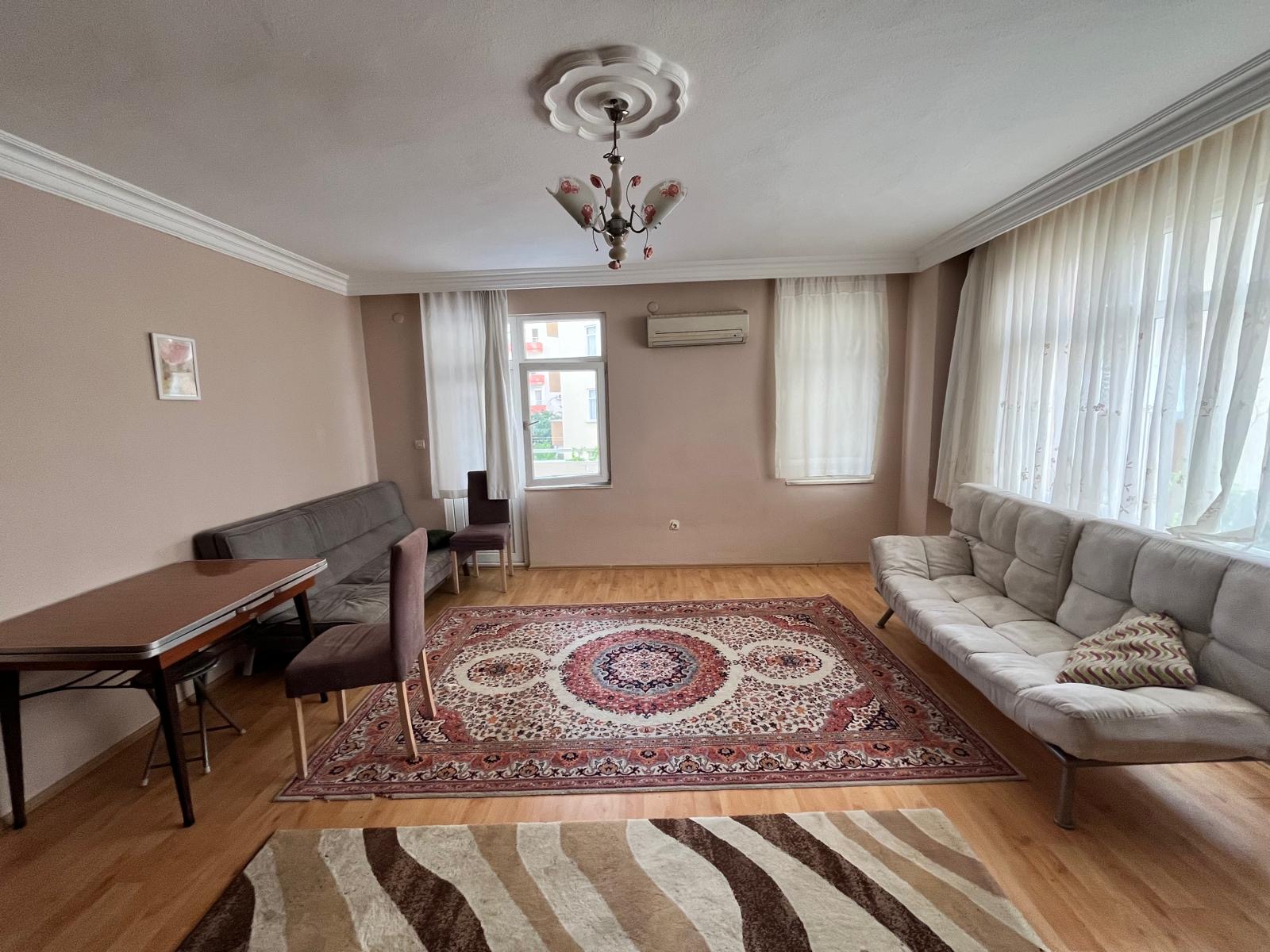 Corner-glazed living room with a light sofa in a flat for sale in Turkey