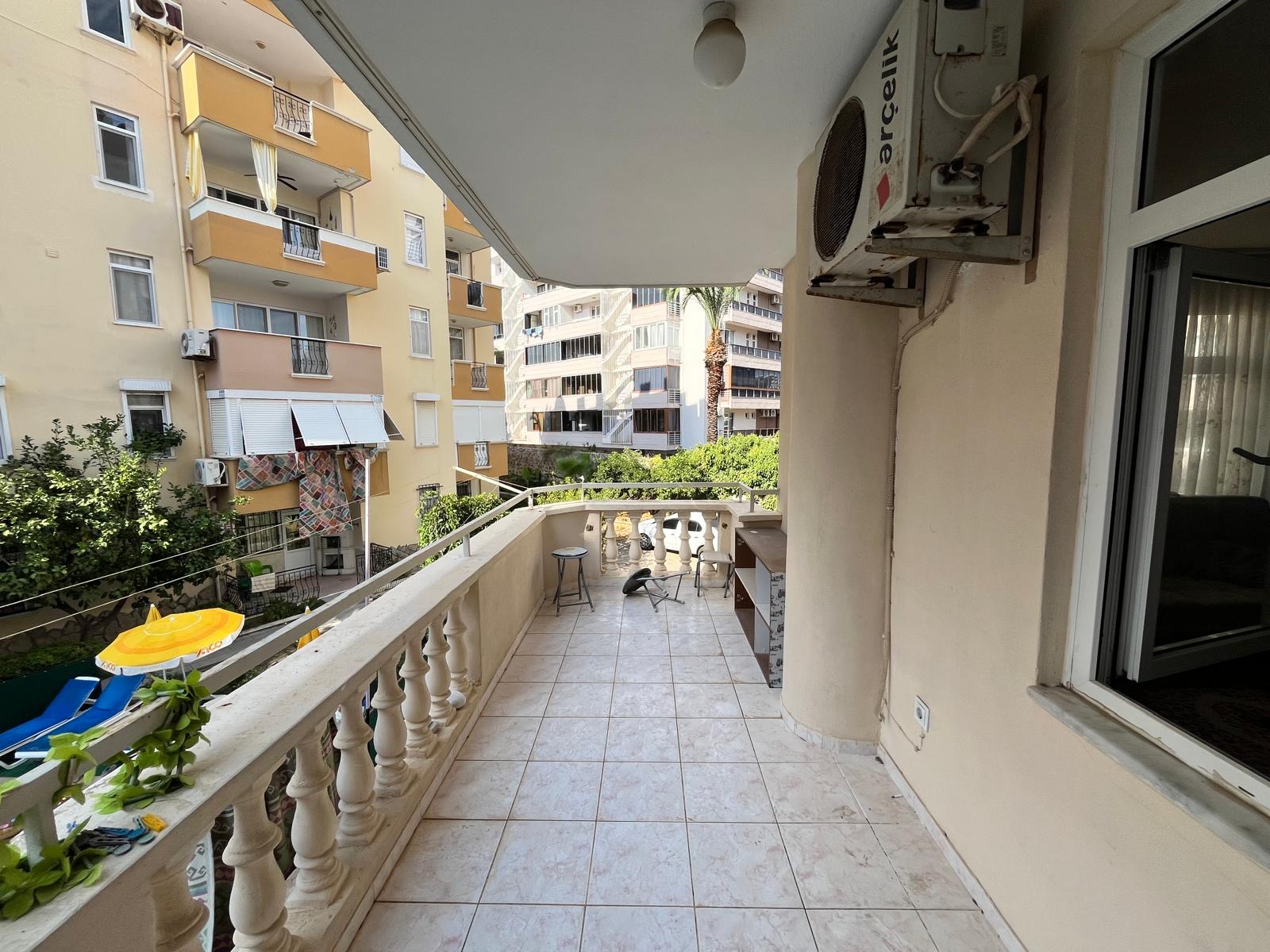 Covered corner balcony with an outdoor table and chairs in a flat offered for sale