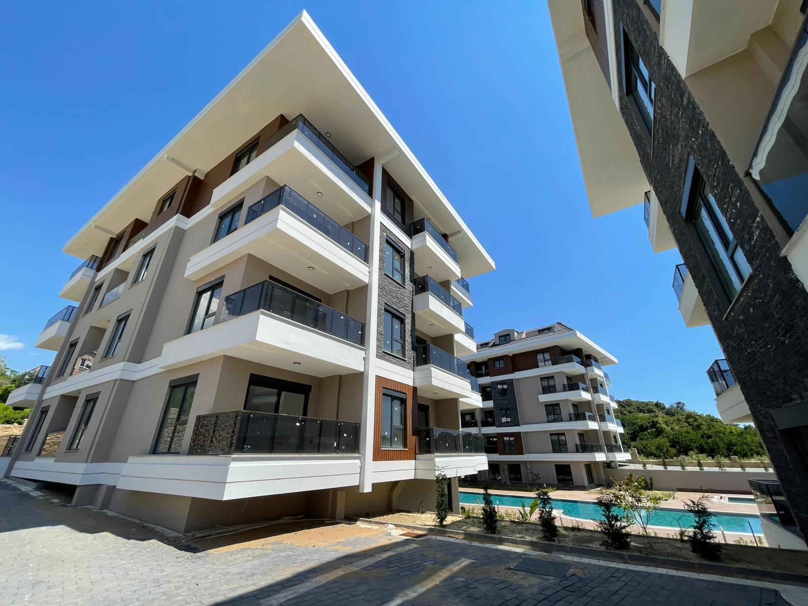 Havuzlu modern blok ve koyu taş cephe: Alanya'nın Oba bölgesinde satılık 2+1 daire, Türkiye — New Level Group