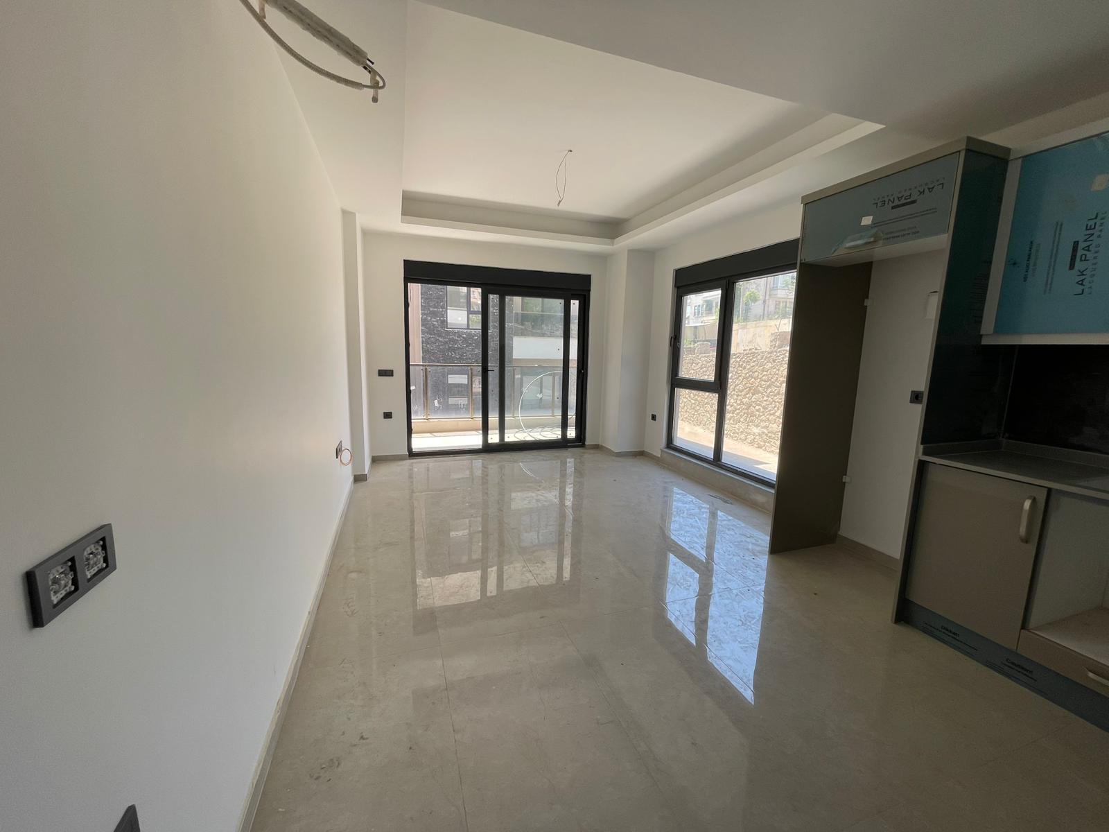 Panoramik sürgülü pencereli boş mutfak-salon, Türkiye'deki konutta siyah tezgâhla