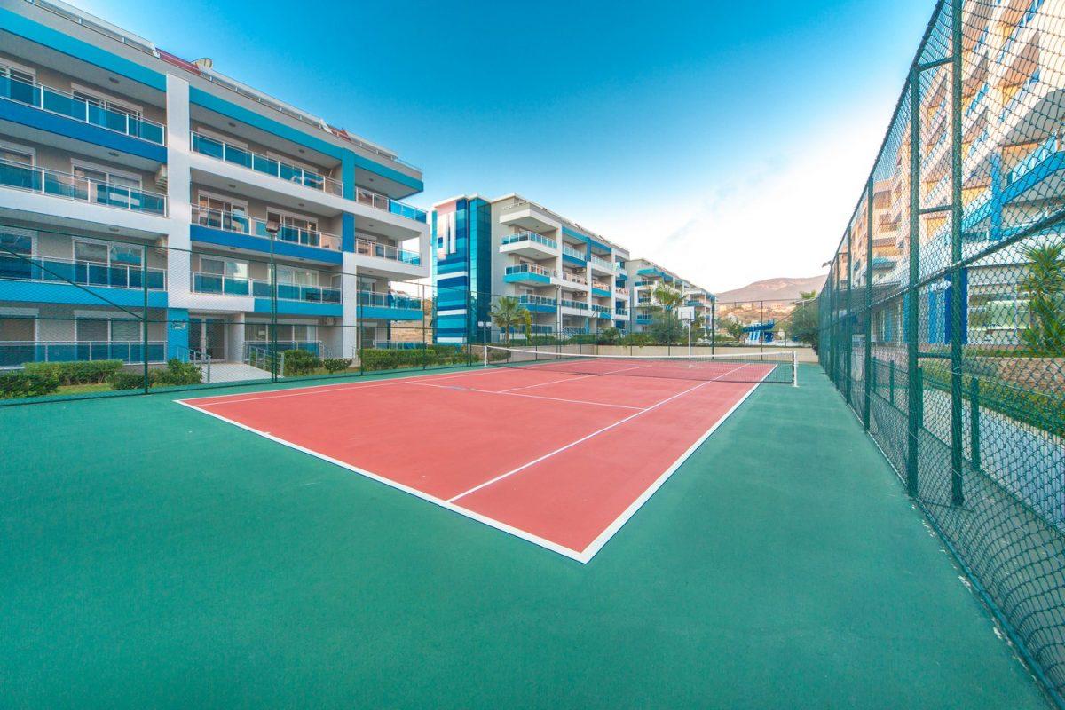 Kırmızı zeminli açık tenis kortu, Kestel’de konutların bulunduğu komplekste dağ manzarasıyla