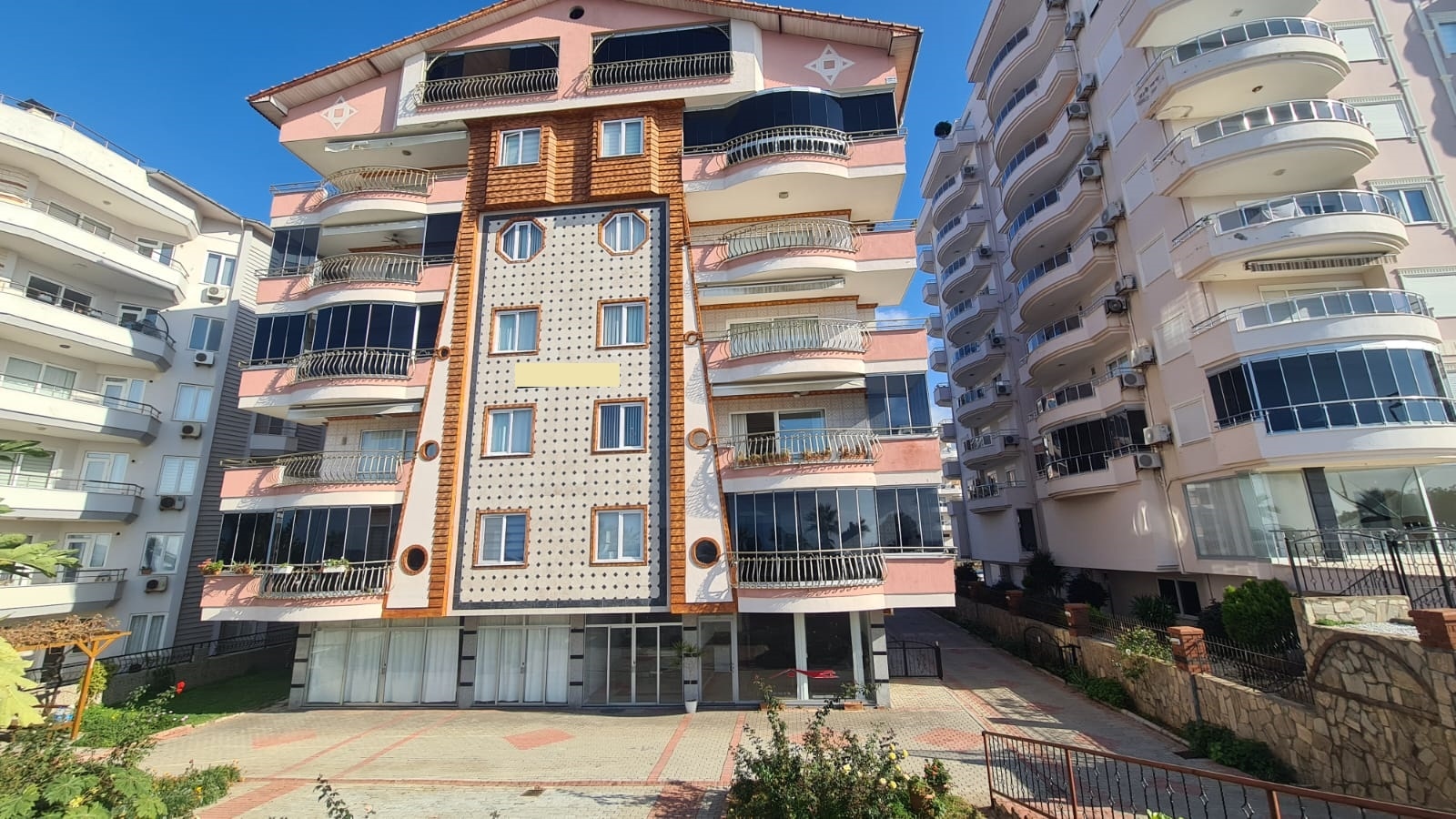Yuvarlak balkonlu pembe bej cephe Mahmutlar'da Türkiye'de rezidans binalarını gösteriyor