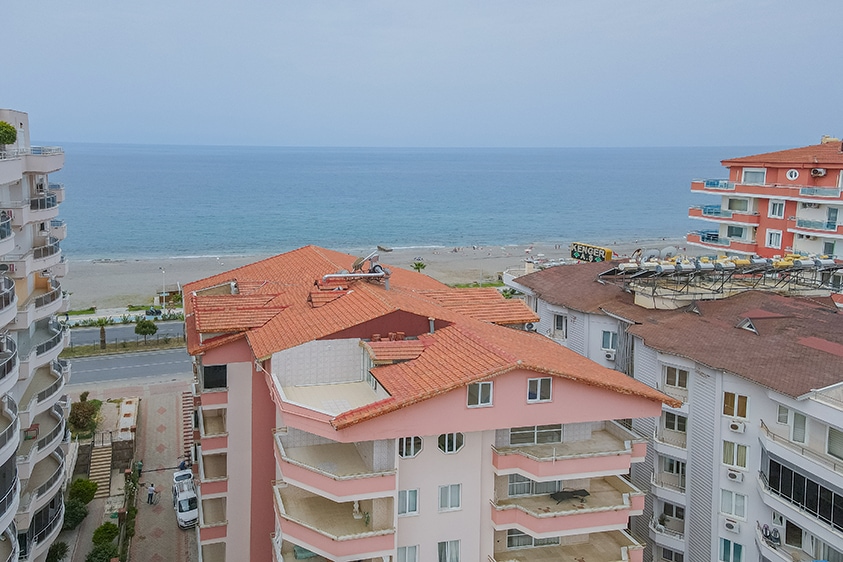 Kumlu çakıllı plaj ve deniz ufku Mahmutlar'da Türkiye'de penthouse terasından görülüyor