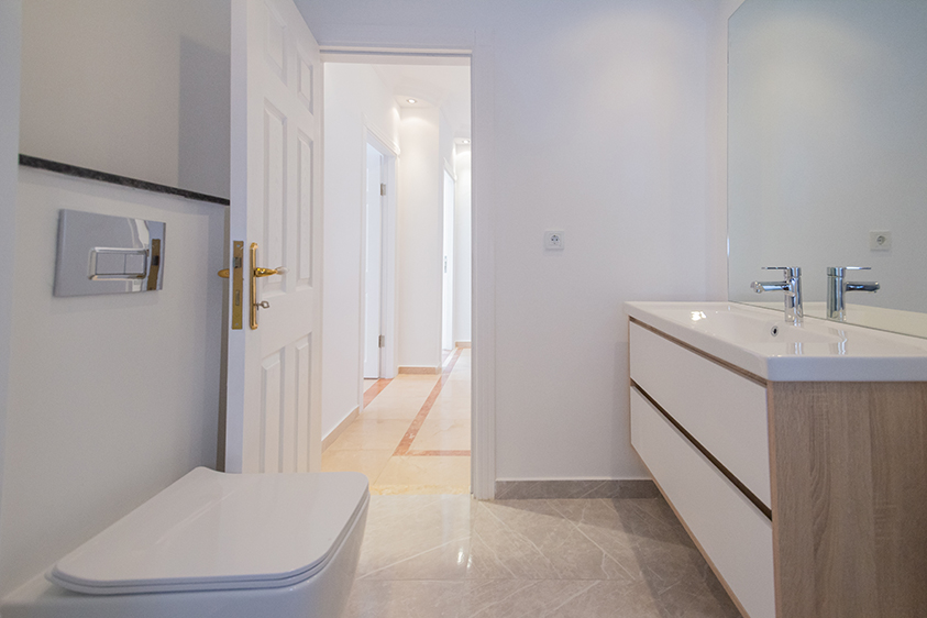 Çift lavabolu banyo büyük ayna ve açık renk mermer zeminli dubleks dairede yer alıyor
