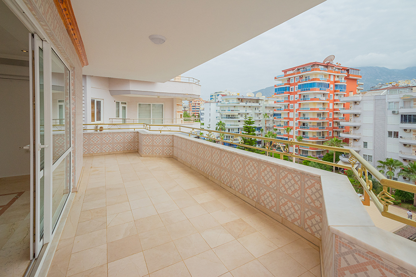 Köşe terası altın renkli korkuluklarla şehir ve dağ manzarasına açılan penthouse içinde