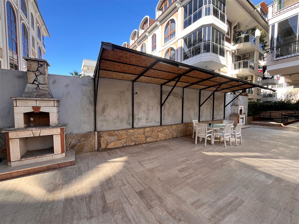 Bitkili gölgelik ve taş mangal Oba’daki Türkiye çatı katı dairelerinin bulunduğu sitede