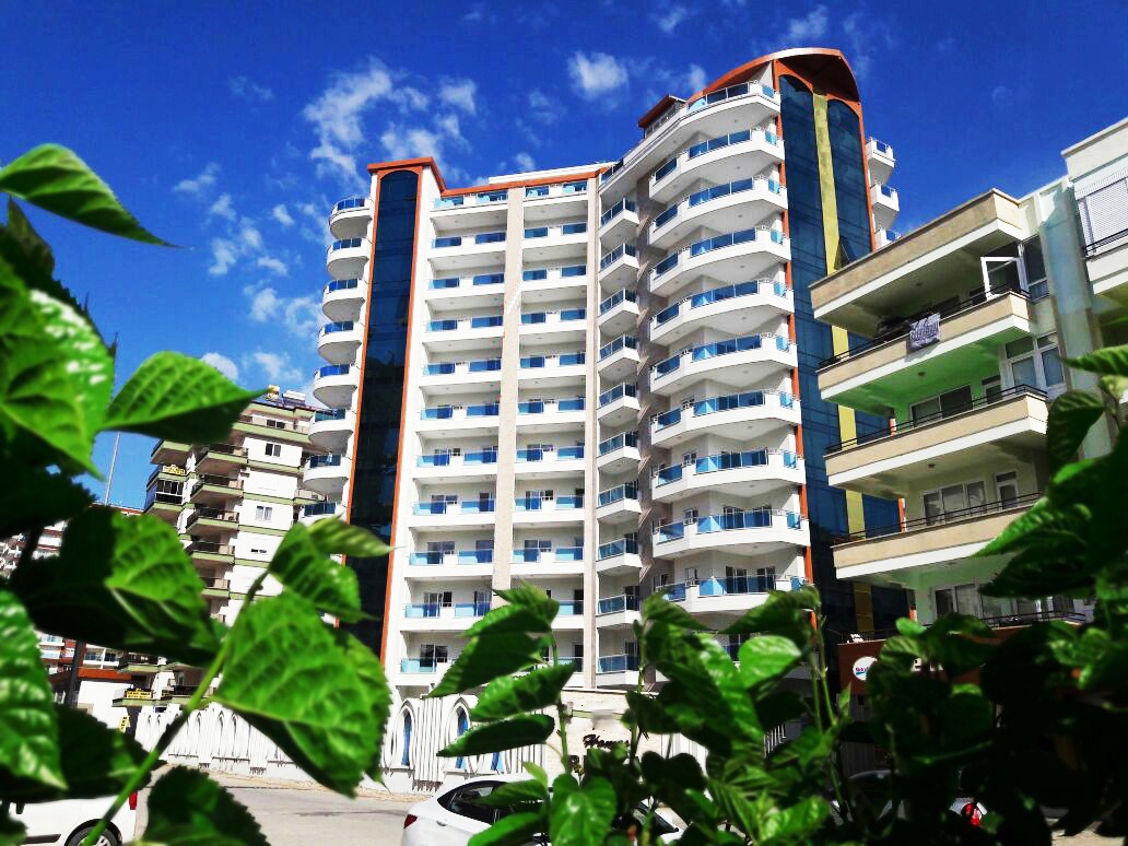 White facade with curved balconies: a 1+1 apartment for sale in Mahmutlar, Alanya, Turkey — New Level Group