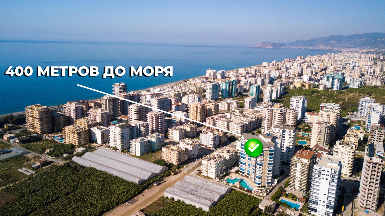 Aerial coastal district with a sea bay and mountain shore, showing 1+1 apartments for sale in Turkey