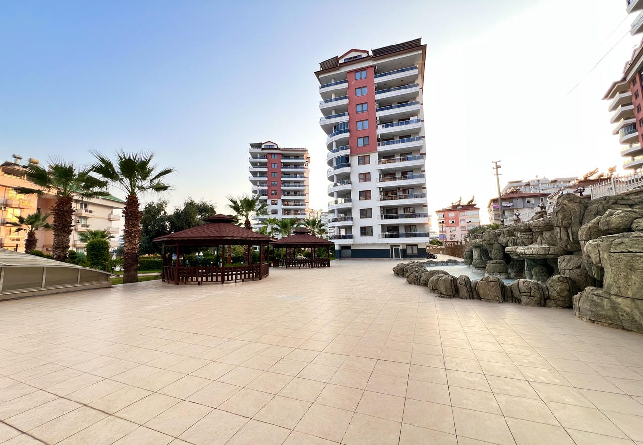 Bungalo ve palmiyeler Çikcilli’de 4+1 rezidansların bulunduğu sitenin taş döşeli alanını süslüyor
