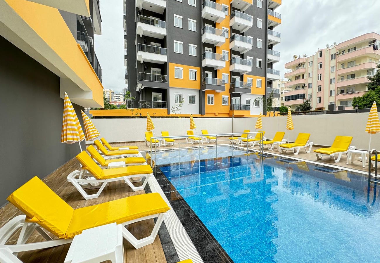 Striped umbrellas and yellow loungers beside the outdoor pool in Mahmutlar