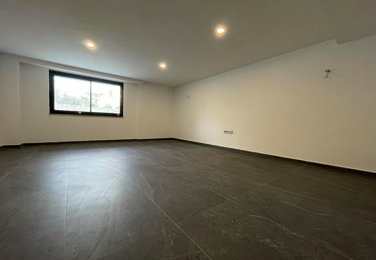 Living room with panoramic window and dark tile in an apartment for sale