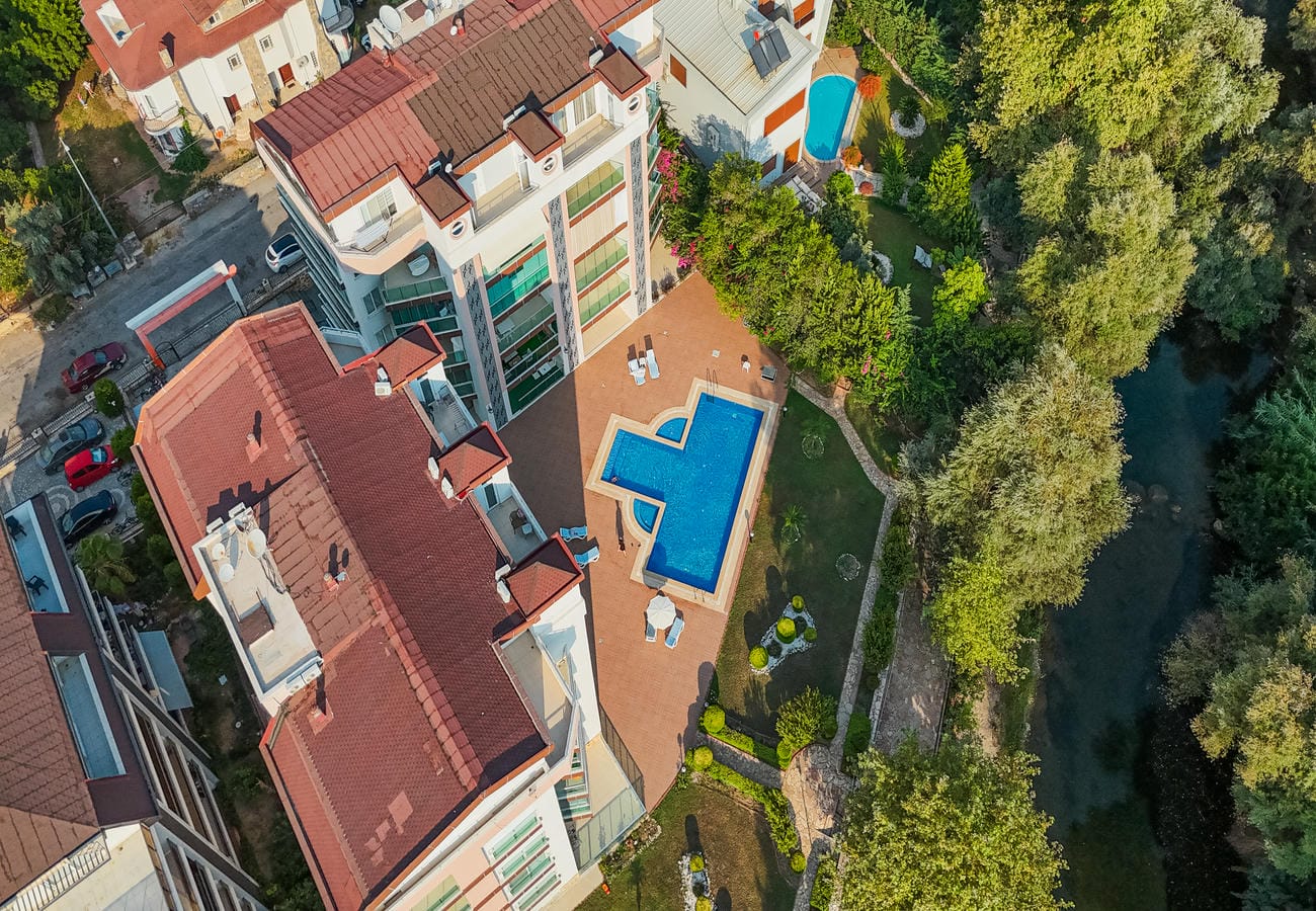 Ağaçlarla çevrili avlu havuzu ve su kanalı, Kestel’de penthouse dairelerin bulunduğu Türkiye sitesinde