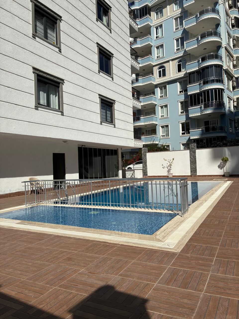 Small outdoor pool with a metal safety barrier in a complex with 2+1 apartments for sale in Mahmutlar