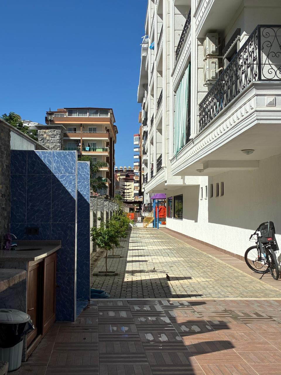Paved walkway along a facade with decorative balconies in a complex where apartments are for sale