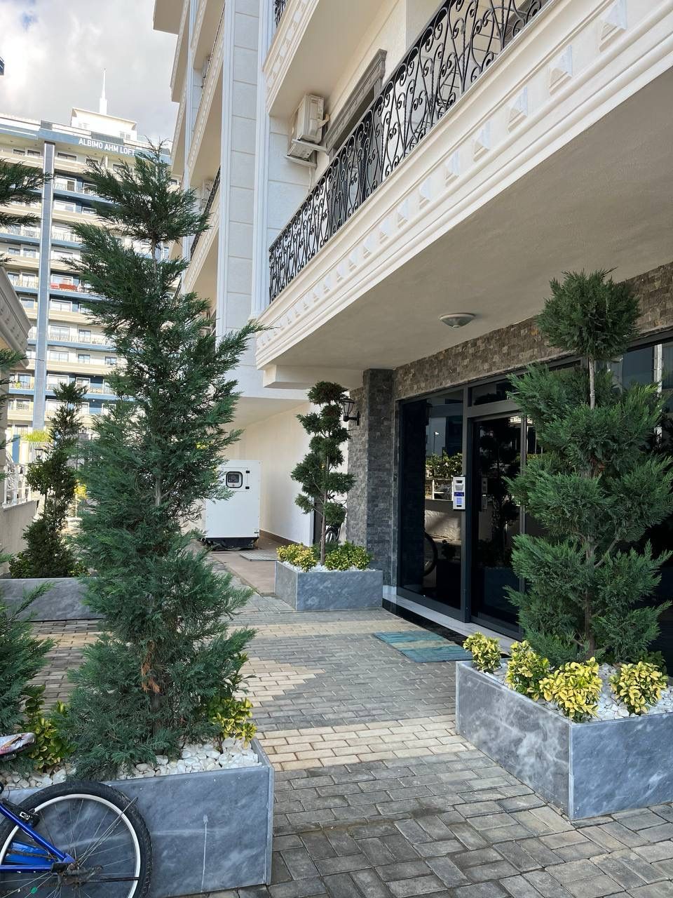 Entrance area with black-framed glass doors and dark stone cladding in Turkey at a complex where apartments are for sale