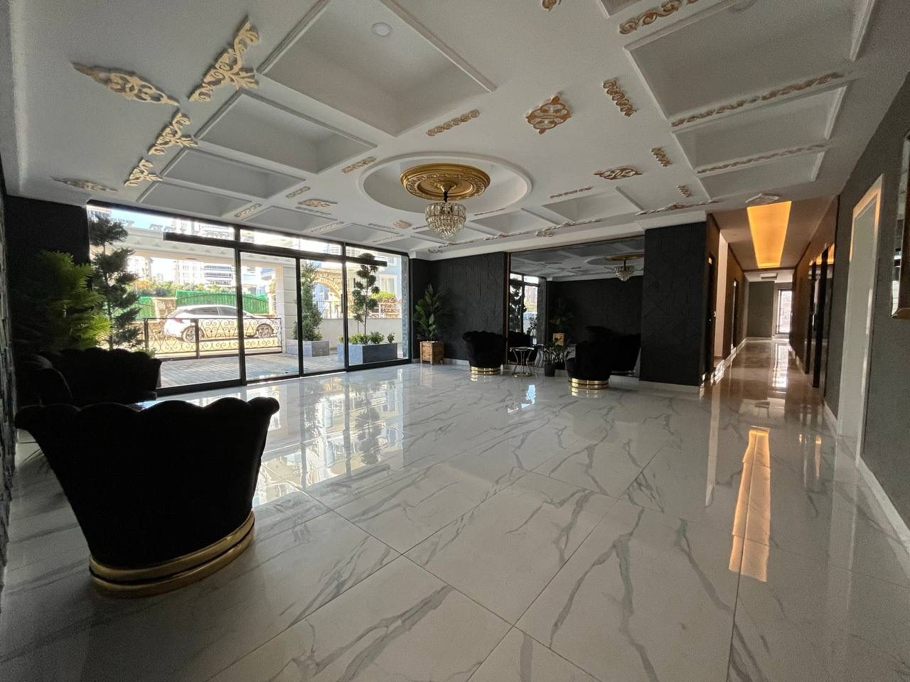 Spacious lobby with marble flooring and a crystal chandelier in a complex where a penthouse is for sale