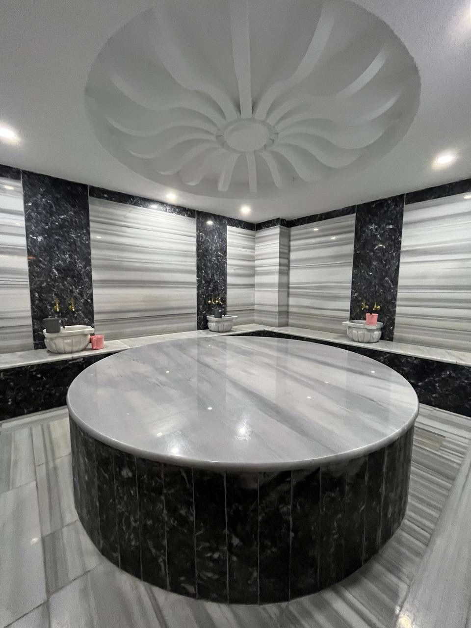 Hammam with a round marble platform and dark marble columns in a complex with apartments in Alanya