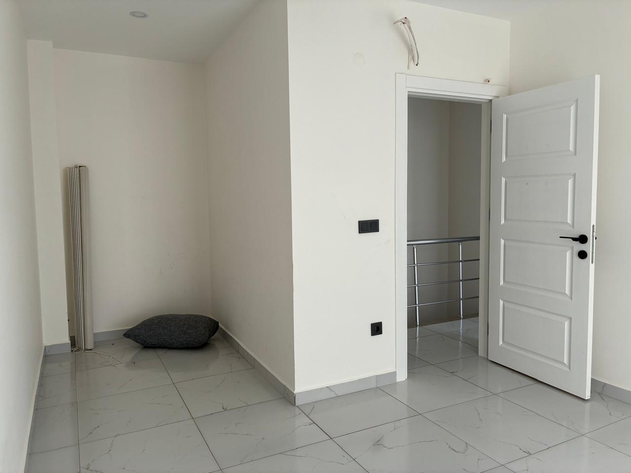 Bedroom with a wall niche, floor mattress and stair railing in a top-floor apartment in Mahmutlar