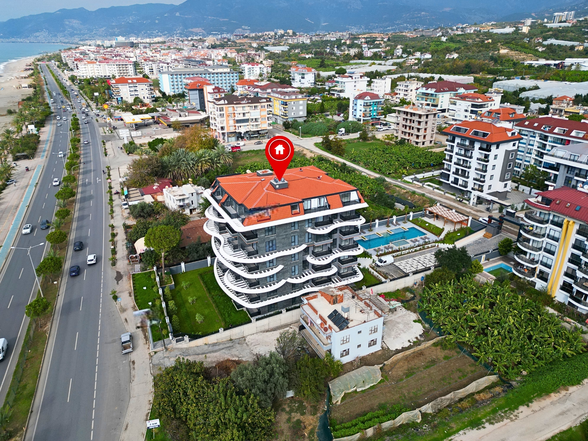 Aerial view of the residential building with curved white balconies by a multilane road in Kestel