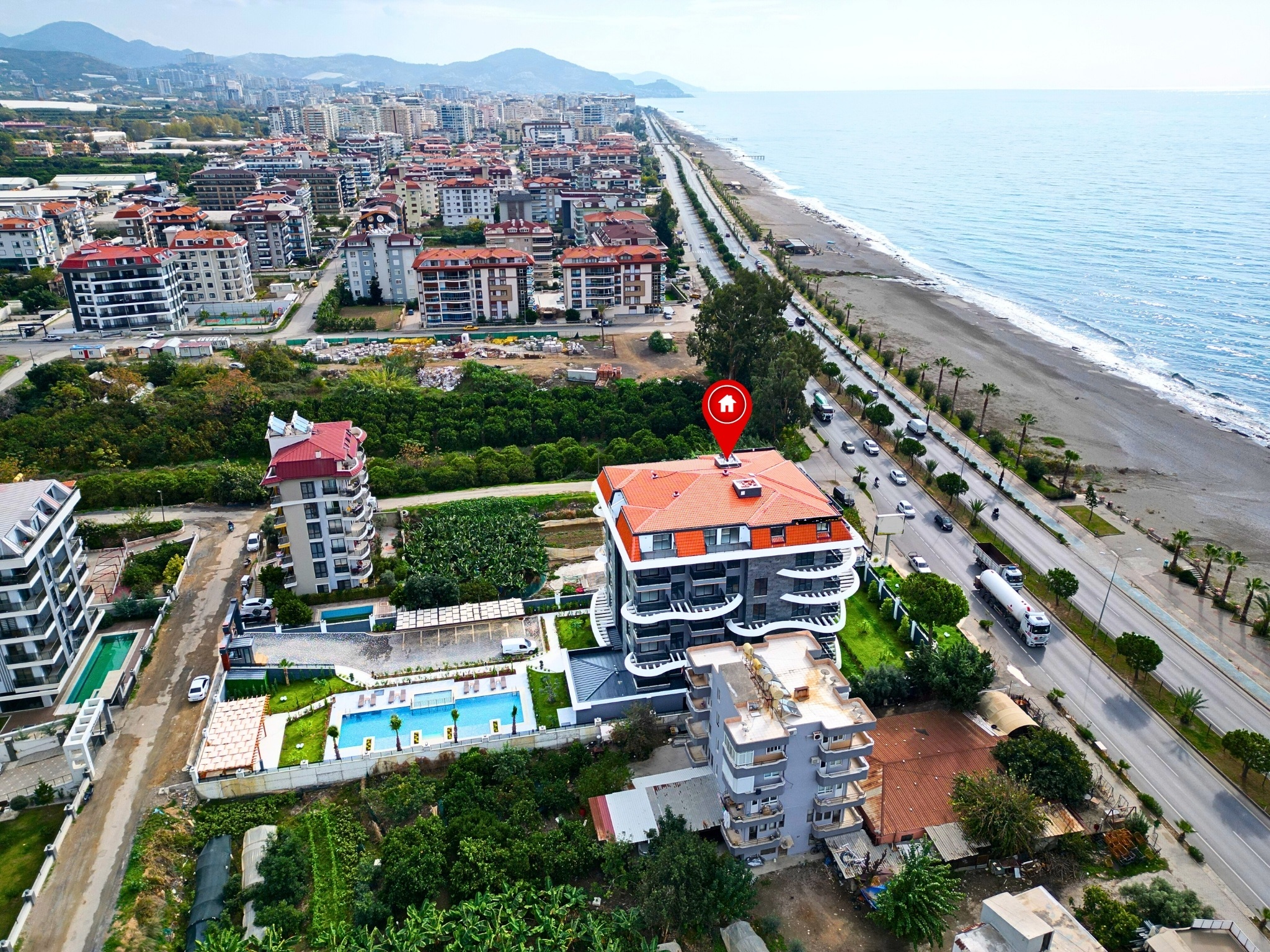 Coastal complex with a pool, loungers and sandy beach on the Mediterranean coast in Türkiye
