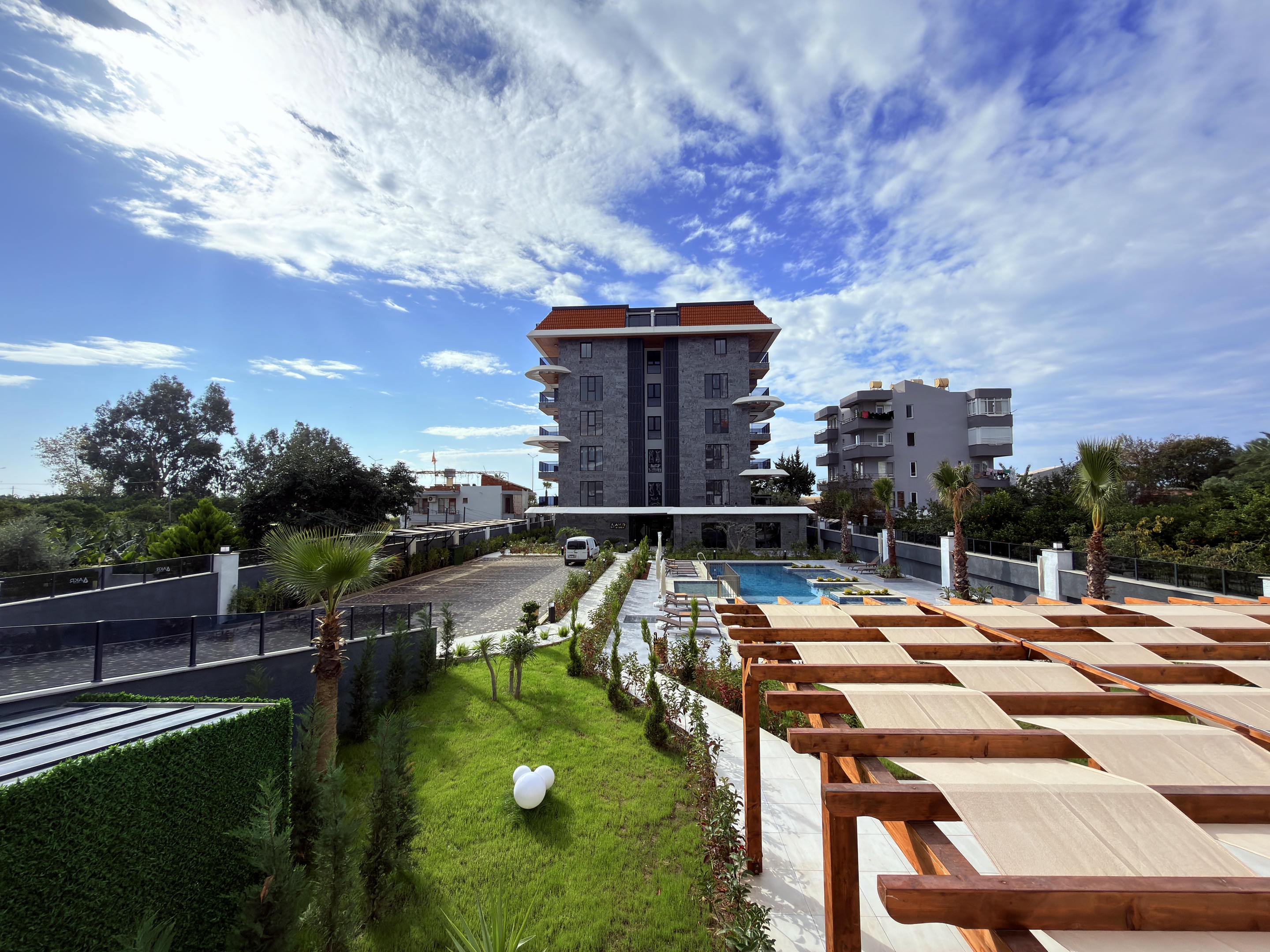 Residential building with pergolas, pool and palms on the grounds of a residence in Kestel, Türkiye
