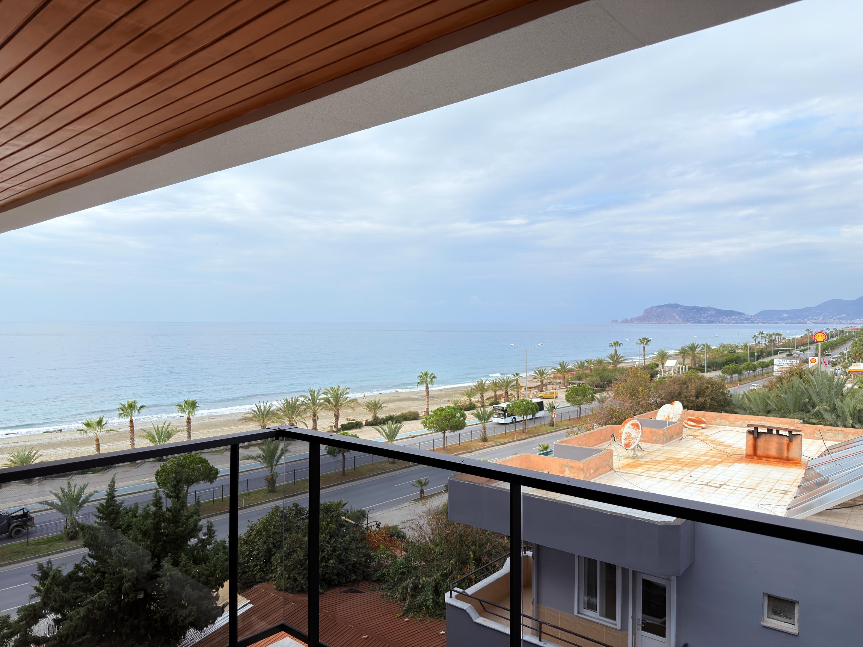 Sea view from a balcony above the sandy beach and coastal road at apartments on the Mediterranean coast in Turkey