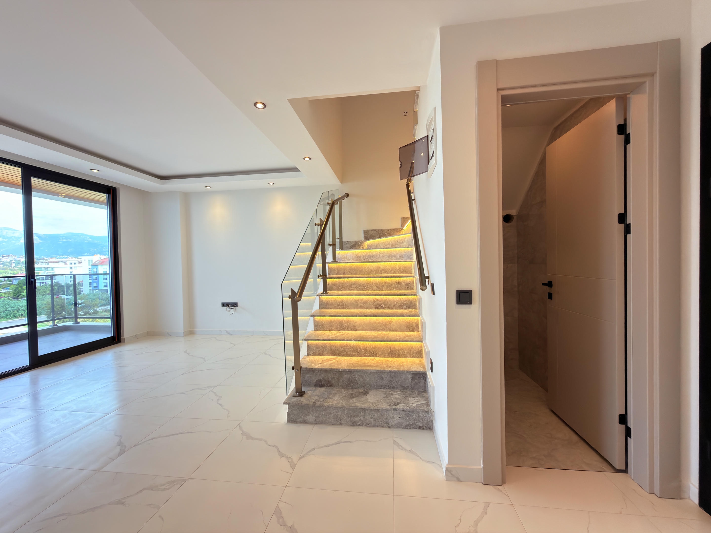 Kitchen-living room with a stone staircase, balcony doors and an open bathroom door
