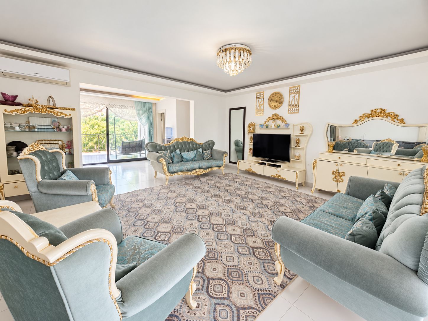 Living room with a blue sofa, crystal chandelier and sliding doors to the terrace in Turkey
