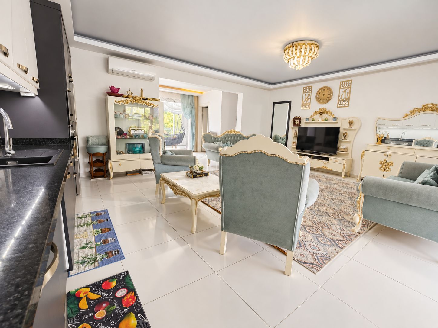 Open-plan kitchen living room in Kargicak offered for sale with blue sofas and a dining table