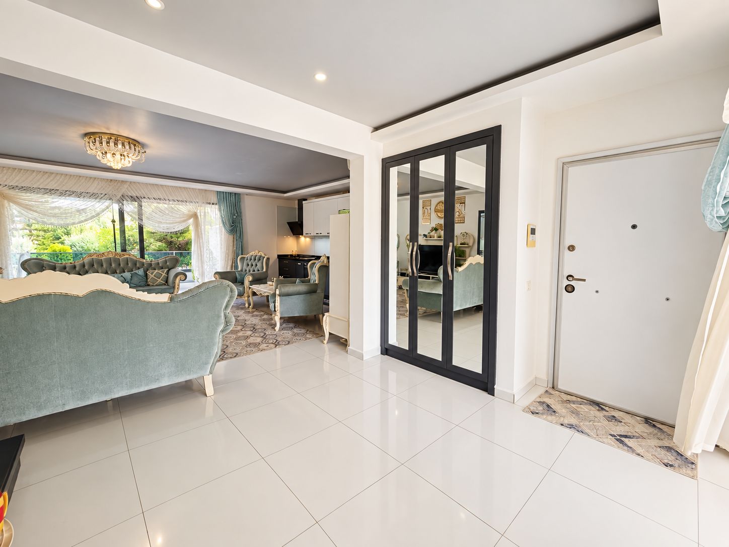 Entrance hall with black glass double doors and a wide opening to the living room in a 2+1 flat
